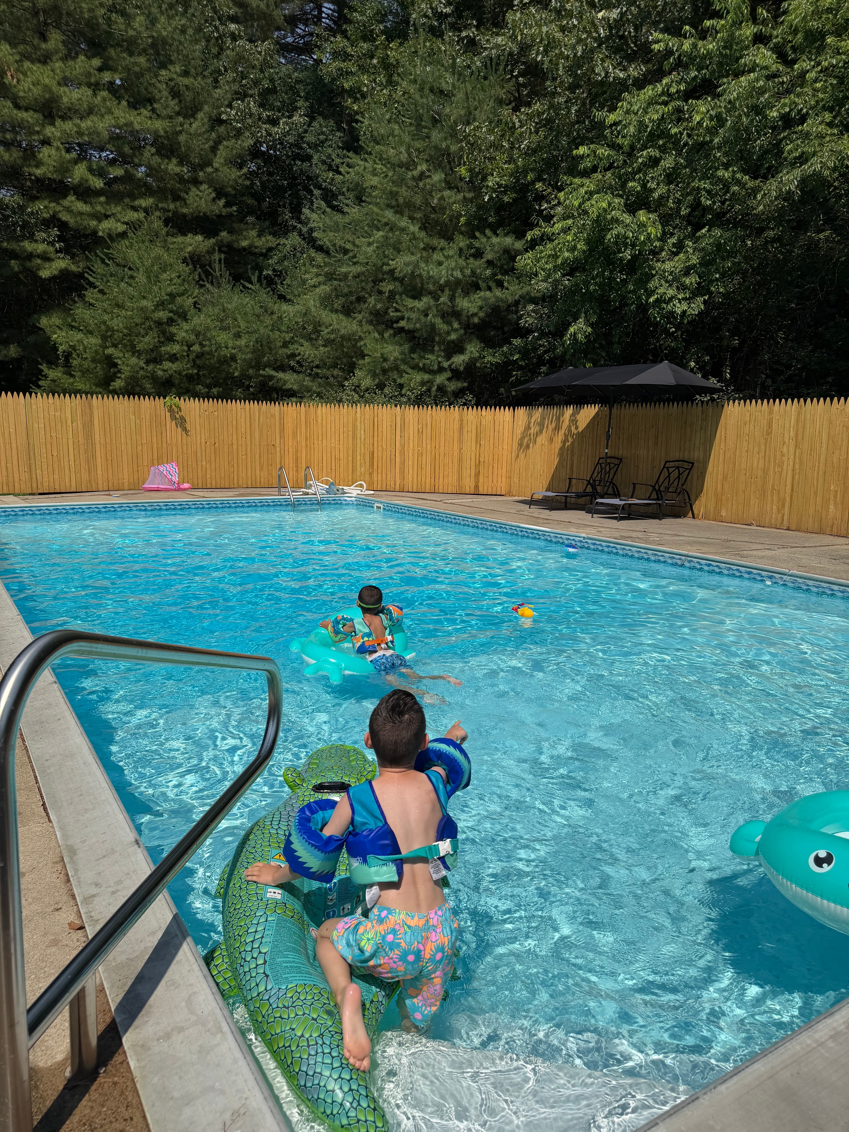 Sabrina's pool after restoration — crystal clear water with children playing on floaties