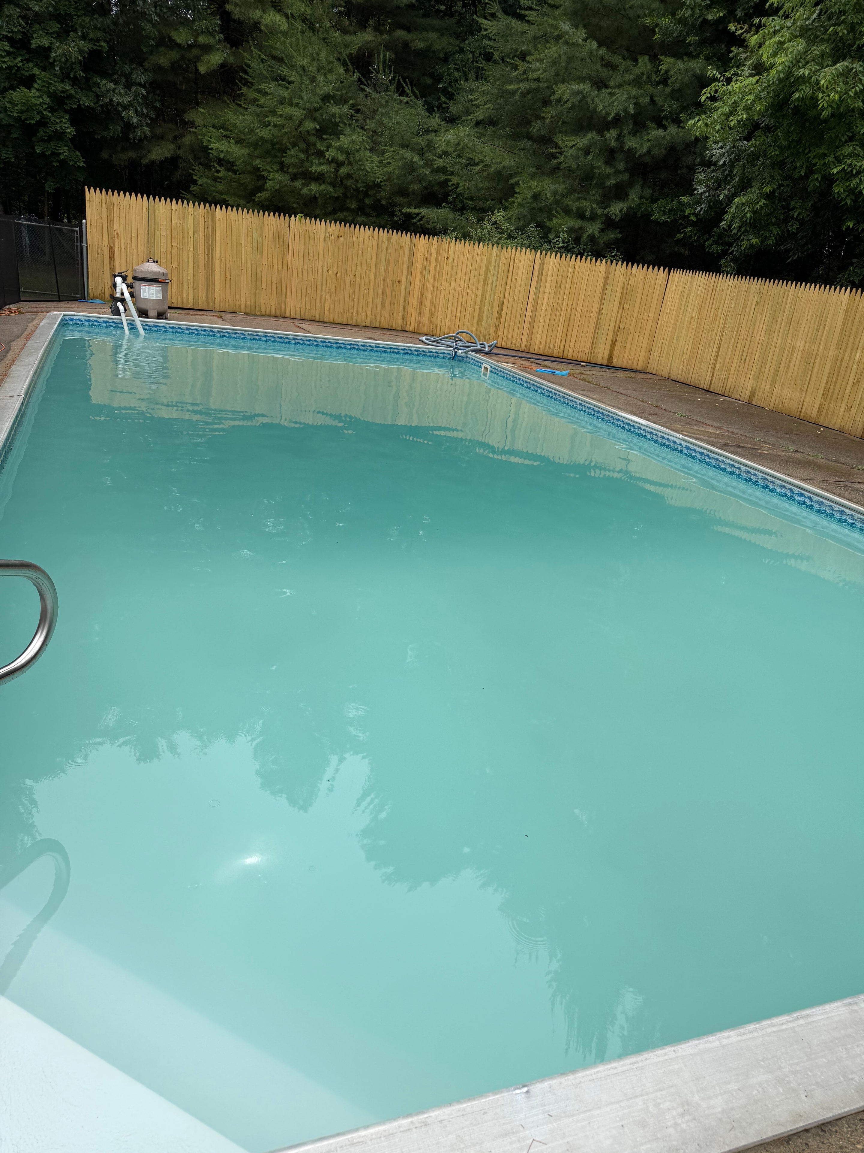Sabrina's pool before restoration — cloudy water with deck visible